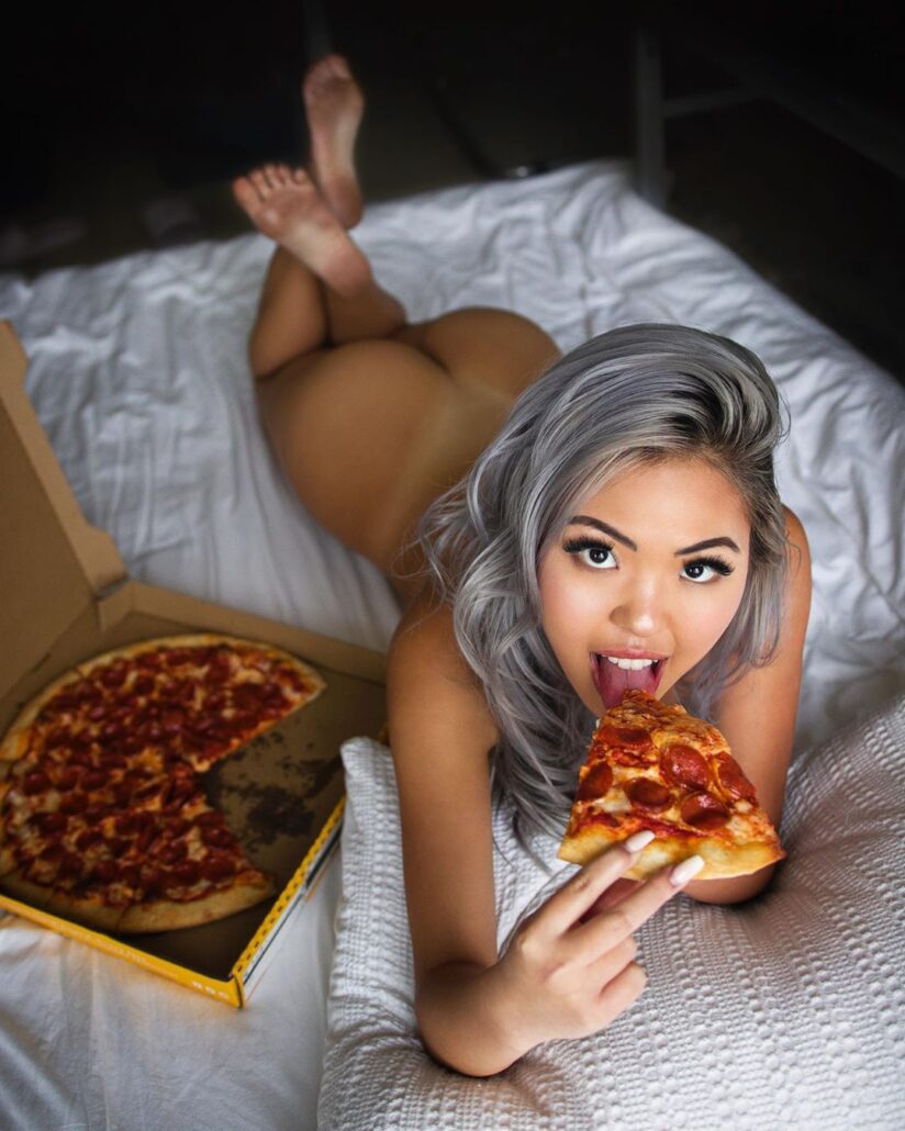 eating on the bed but giving me a playful look that means my dick is much more tasty than the pizza